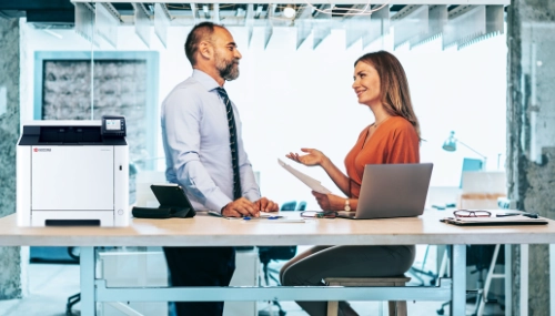Employees discussing beside printer
